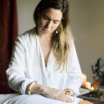 Gemma realizando una sanación energética con las manos junto a un altar de Ganesha